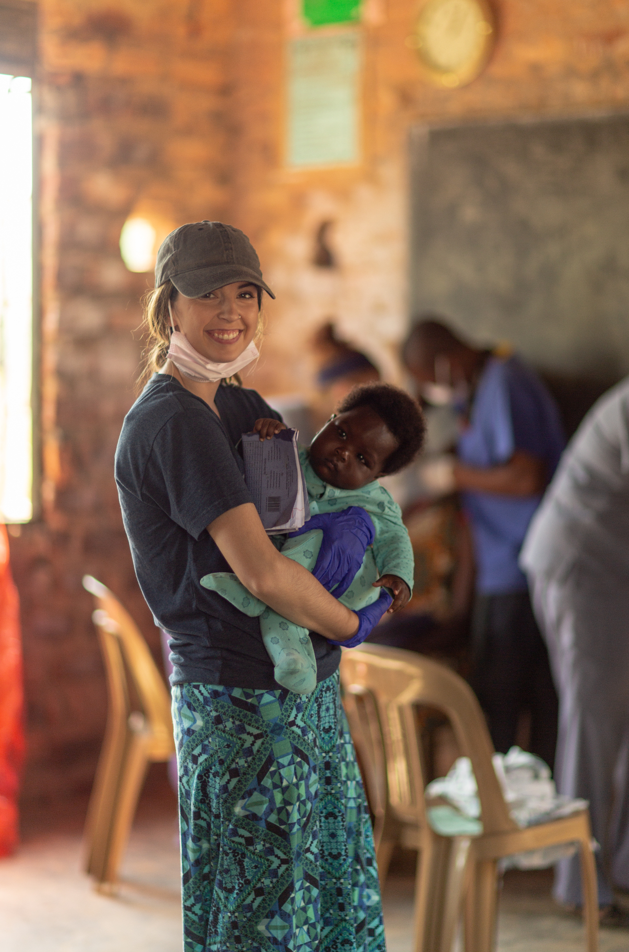 A volunteer holding a baby during a Mukisa healthcare mission in Uganda